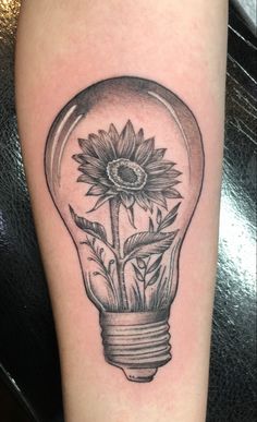 a sunflower in a light bulb tattoo on the leg