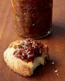 a piece of bread sitting on top of a wooden table next to a jar of jam