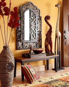 a table with vases, mirror and giraffe statues on it