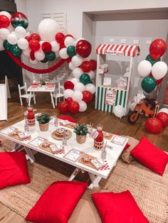 a room decorated for christmas with red, white and green balloons