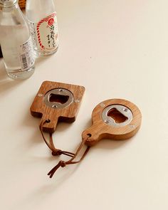 two wooden bottle openers sitting on top of a white counter next to a bottle