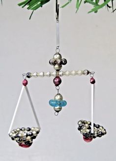 an ornament hanging from a christmas tree with beads and glass balls on it