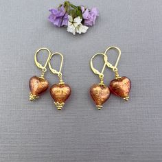 ✦These puffy heart Venetian Murano glass heart earrings make the perfect jewelry gift for her!   ✦Authentic Murano glass Heart in transparent Murano glass in a beautiful Rubino pink and red color over 24kt gold foil with gold daisy spacers or fancy crown detailing adorning the hearts, as shown in several pictures.  ✦The hearts measure 12mm in length. 14k gold-filled French hook or lever back ear wires. ✦Please select ear wire style and simple daisy spacer or fancy crown detailing at check out. ✦Want to upgrade your earrings with solid 14k gold ear wires? Click here to purchase the upgrade: https://www.etsy.com/listing/1198680050 ✦Need to convert your earrings to clip-on, non-pierced ear wires? Click here to purchase the upgrade: https://www.etsy.com/listing/706005409 ✦Click here to see my Fancy Crown, Beads Gifts, Murano Jewelry, Pierced Ear, Diy Jewelry Projects, Mothers Day Gifts, Puffy Heart, Leverback Earrings, Jewelry Card