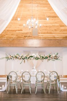 the reception table is set up with white linens and floral centerpieces