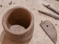 there is a clay pot and tools on the table