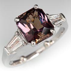 an engagement ring with a fancy pink diamond and baguettes on the sides, set in white gold