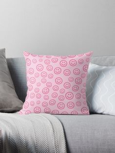 a pink pillow sitting on top of a gray couch