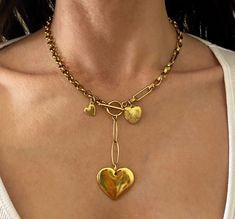 "Elegant Sophie" necklace This is a beautiful chain necklace with 3 heart charms . It is made of two types of steel chains that connect and closure at the front with a toggle bar .  Hearts are made of gold plated 24k zamac .  Dimensions:  Rolo chain thickness: 0.5 cm  Link chain size : 1.8 x 0.6 cm  Hearts sizes  Big heart 3 x 2.5 cm Mid heart : 1.5x1.5 cm Tiny heart : 1 cm  This necklace has an elegant and luxury finish . Ideal for all the day and going out . Also great gift idea !  It is available in various lengths as linked to options . In the pictures I wear the mid length if 46 cm long . Please also note that the 42 cm it's a very short length, I would recommend it to petites . ------------ ⚜️Everything is taking place in a private clean organsized smoke-free studio.  ⚜️on some piece Chain Necklace With Charms, Necklace With Charms, Charms Necklace, Toggle Necklace, Necklace Heart, Gold Heart Necklace, Tiny Heart, Big Heart, Gold Heart