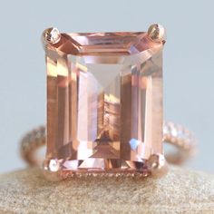 This Diamond Prong Morganite Ring is part of our Olivia Collection, which is characterized by a gorgeous, genuine gemstone with Golden Hearts under it. Diamonds stud the hidden halo and sparkle down the half eternity shank. Custom initials at the back of the shank are available on all rings upon request! Center Stone: Genuine AAA Peachy Pink Morganite, Emerald Cut, averaging 15x12mm and 10 carats. Side Stones: 68 Diamonds - you choose Lab Grown or Organic - averaging F-G, VS2-SI1 and 0.46 carats Radiant Cut Morganite Wedding Jewelry, Classic Morganite Jewelry With Prong Setting, Radiant Cut Morganite Rings For Anniversary, Rose Gold Octagon Ring With Prong Setting, Morganite Radiant Cut Jewelry For Anniversary, Rose Gold Octagon Jewelry With Prong Setting, Radiant Cut Rose Gold Ring With Gemstone, Exquisite Morganite Jewelry For Anniversary, Wedding Jewelry With Vvs Clarity Morganite