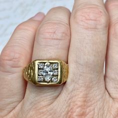 a woman's gold ring with three diamonds on it, in the middle of her hand