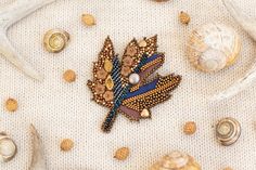 an embroidered brooch with buttons and beads on it, surrounded by seashells