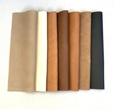 five different colors of leather on a white surface