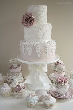 a wedding cake and cupcakes on a table