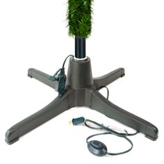 a green plant sitting on top of a gray stand next to a computer mouse and headphones