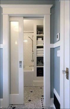 an open door leading to a bathroom with black and white floor tiles on the walls