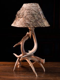 a lamp made out of antlers on top of a wooden table