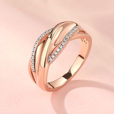 Stylish and stunning, this band will be a nice holiday gift for mom, sister, friend, or yourself! Crafted in rose gold-tone sterling silver, this band will catch every lady's eyes with its delicate intertwined shank. Stones are well set on two of the shanks to add sparkle to it. This unique band is a glittering gift of the truest love.Carat Weight: 0.26 ctStone Size: 1 mmStone Type: Jeulia® StoneNumber of Stones: 26 Stone Color: Diamond WhiteStone Shape: RoundWeight: 4 gWidth: 3 mmHeight: 3.4 mmThickness: 1.3 mmMaterial: 925 SilverPlating Color: Silver, Rose Gold Elegant Adjustable Rose Gold Rings, Elegant Jewelry With Shiny Finish For Promise Ring, Rose Gold Open Band Jewelry For Gift, Classic Rose Gold Open Band Jewelry, Elegant Rose Gold Jewelry With Shiny Finish, Fine Jewelry In Rose Gold With Shiny Finish, Rose Gold Fine Jewelry With Shiny Finish, Elegant 14k Rose Gold Jewelry, Nice Holiday