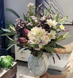 a woman holding a vase with flowers in it