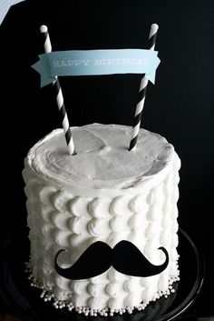 a birthday cake with a mustache and two candles