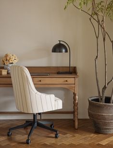 a white chair sitting next to a potted plant on top of a wooden table