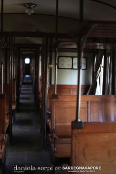 the inside of a train car with wooden seats