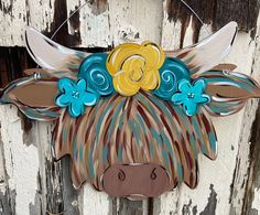 a cow with flowers on it's head hanging from a door