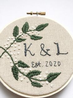 a close up of a embroidery on a white surface with the initials k and l