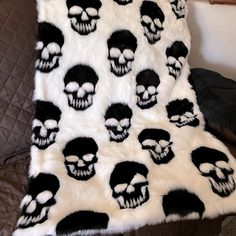 a white and black blanket with skulls on it