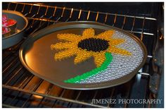 a pan with beads in the shape of a sunflower sitting on an oven rack