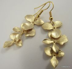 These gold orchid earrings are so sophisticated, delicate and simply stunning. They are perfect for any occasion and they make a wonderful bridal gift - for the bride or the bridesmaids! These earrings feature three lightweight, cascading matte gold plated orchids. They are finished off with gold plated ear wires. The ear wires can be switched out to stainless steel, for those with sensitive ears, or gold plated clip-ons at no additional charge. Simply select your option before adding to your ca Elegant Orchid Flower Jewelry, Elegant Orchid Flower Earrings, Gold Flower Earrings For Bridesmaid Gift, Dainty Yellow Gold Flower Earrings For Wedding, Delicate Yellow Gold Flower Earrings For Wedding, Gold Dangle Flower Earrings For Bridesmaids, Yellow Gold Flower Earrings For Wedding, Gold Flower Earrings For Bridesmaids, Delicate Gold Bridal Earrings As Gift