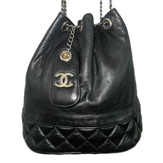 Rare Vintage Authentic 1980’s Chanel Black Lambskin Drawstring Bucket Bag. The Leather Is Butter Soft. Closure Is By Leather And Chain Drawstring. The Gold Plated Icon Is A 4” Lambskin Hang Tag. The Chain Has A 20” Drop To The Top Of The Bag. Inside Is The Black Leather. This Wonderful Bag Has Been Taken Very Good Care. Excellent Condition. #Chanel1 Chanel #1, Drawstring Bucket Bag, Bag Inside, Chanel Bags, Chanel Black, Bucket Bag, The Black, Black Leather, Butter