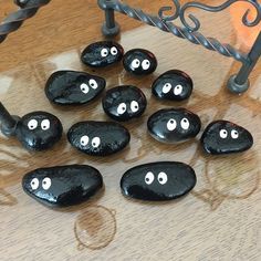 black rocks with eyes painted on them sitting on a table