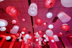 red and white lanterns hang from the ceiling in a room with pink lights on it