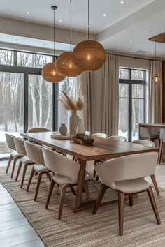 a dining room table surrounded by chairs and lights in front of a large window with lots of windows