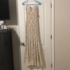 a white dress hanging on a door with a blue hanger in front of it