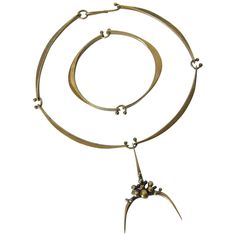 This hand wrought, sculptural bronze set attributed to Jack Boyd combines an organic modern simplicity with a hint of brutalism. The elegantly curved sections of the neck ring and bracelet are joined by playful wire links. The pendant features a cluster of spores. Neither piece is signed, which is not unusual for Boyd's work. approximate measurements: necklace- - overall 5.25" wide x 7.88" long x .5" deep - interior measurement 4.75" wide x 4.75" high - interior circumference of the neck ring is Modernist Bronze Brass Jewelry, Modern Hand Forged Bronze Jewelry, Contemporary Sculptural Jewelry For Formal Occasions, Modern Electroformed Metal Jewelry, Sculptural Necklace, Bronze Cuff Bracelet, Ring And Bracelet, Abstract Pendant, Neck Ring