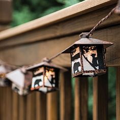 some lights that are hanging from a wooden fence