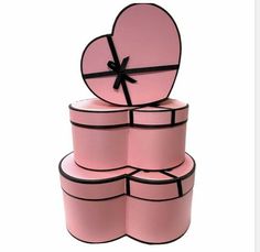 four pink boxes stacked on top of each other with a black ribbon around the edges