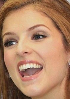 a close up of a woman smiling with her mouth open