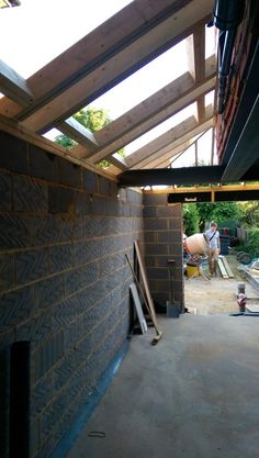 a man is working on the roof of a building under construction with bricks and wood