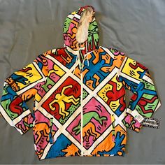 Description: Members Only Is A Reliable Brand For Men's Jackets That Are In Vogue. You Will Find This Men's Keith Haring X Members Only Windbreaker Jacket To Have A Unique Style, Which Is Ideal For The Fun-Loving And Modern Generation. This Multicolor Jacket Has A Mesh Lining And A Poly Taslon Shell. Featuring: Water Resistant Poly Taslon Shell Mesh Inside Lining Hood Drawstring Logo Rubber Patch Original Keith Haring Artwork Urban Multicolor Windbreaker For Spring, Casual Multicolor Windbreaker For Fall, Multicolor Urban Windbreaker For Spring, Urban Style Multicolor Spring Windbreaker, Multicolor Patchwork Windbreaker For Outdoor, Urban Multicolor Spring Windbreaker, Urban Style Sports Windbreaker With Graphic Print, Artistic Graffiti Print Outerwear For Streetwear, Keith Haring Clothing