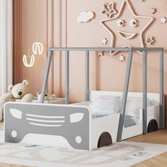 a child's bedroom with pink walls and white furniture, including a grey bed frame