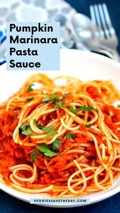 pumpkin marinara pasta sauce in a white bowl on a blue tablecloth with silverware