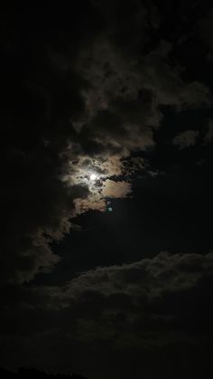 the full moon shines brightly in the dark night sky with clouds and trees below