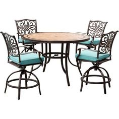 an outdoor dining table with four chairs and a round wooden table topped with blue cushions