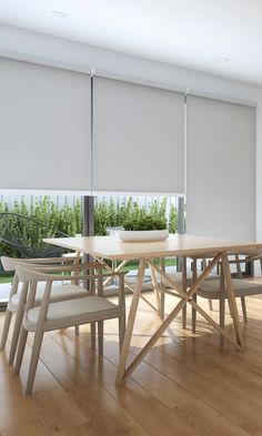 a dining room table and chairs with blinds on the windowsills in front of them