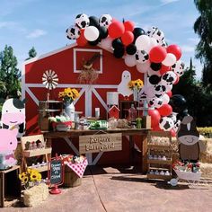 a farm themed birthday party with balloons and decorations on the side of a red barn