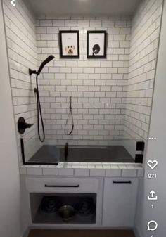 a bathroom with white tile and black accessories