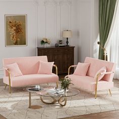 a living room with two pink couches and a coffee table in front of a window