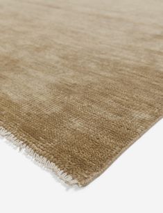 a beige rug with fringes on it